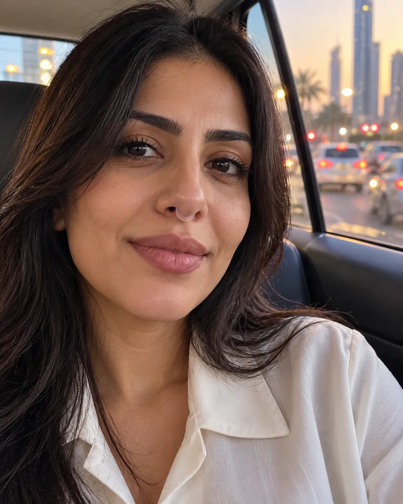 A woman in the back of a taxi at sunset wearing NASMA
